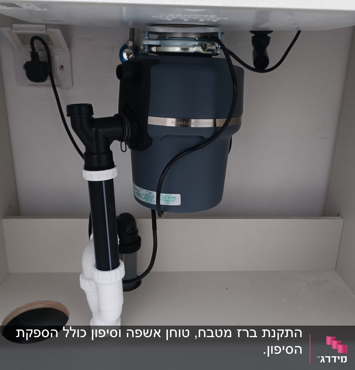 מכשיר טוחן אשפה מותקן מתחת לכיור עם צנרת